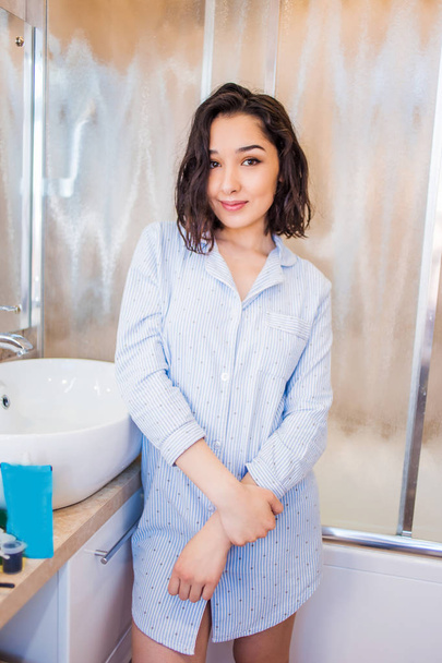Young smiling woman in the bathroom after a shower. Spa, care concepts - 写真・画像