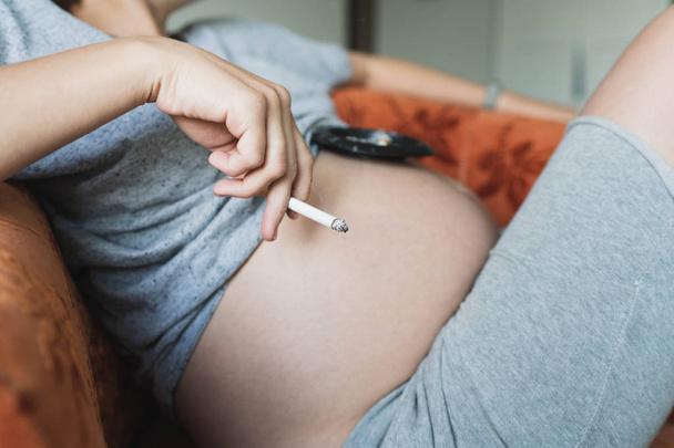 Pregnant woman smokes a cigarette - Фото, зображення