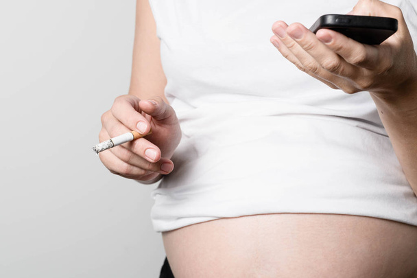 Беременная женщина курит сигарету
. - Фото, изображение