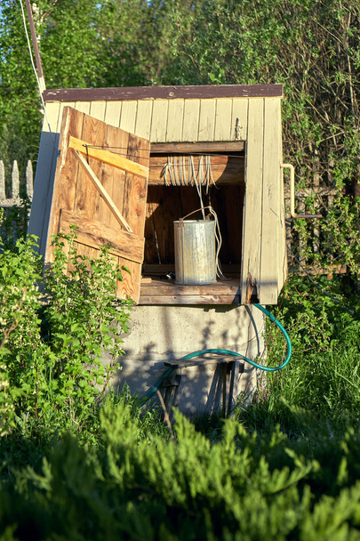 Tradycyjne drewniane kopalń z metalowym wiadrze na wsi w letni dzień - Zdjęcie, obraz