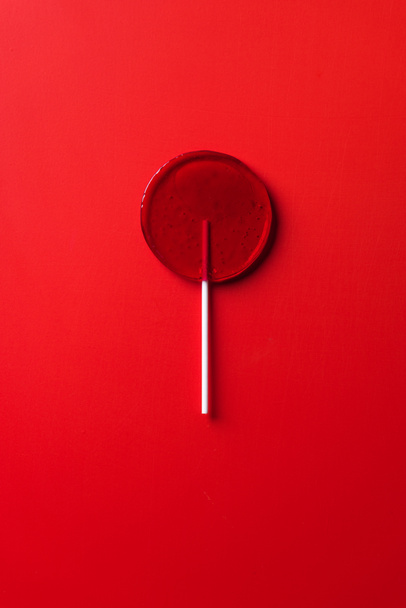 top view of one lollipop on red surface - Φωτογραφία, εικόνα