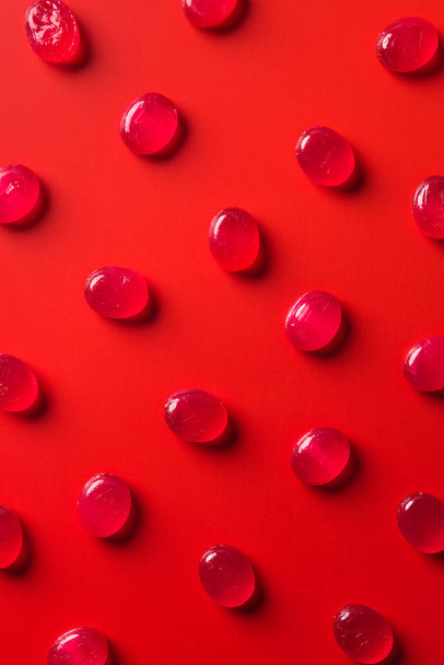 top view of collection of candies on red surface - 写真・画像