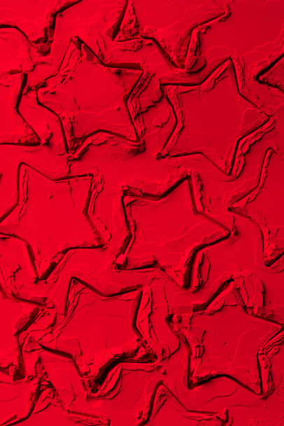 κάτοψη του σχήματα του κόπτες μπισκότων σε σχήμα αστεριών την κόκκινη σκόνη  - Φωτογραφία, εικόνα