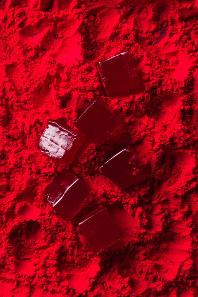 top view of scattered candies on red powder - Φωτογραφία, εικόνα