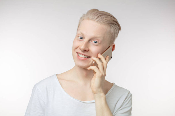 Young cheerful businessman typing sms on his smartphone - Valokuva, kuva