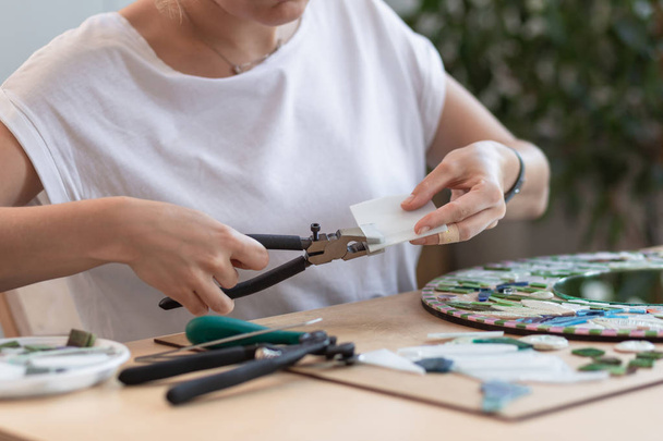 Lugar de trabajo del maestro del mosaico: las manos de las mujeres herramienta para los detalles del mosaico en el proceso de fabricación de un mosaico
 - Foto, Imagen