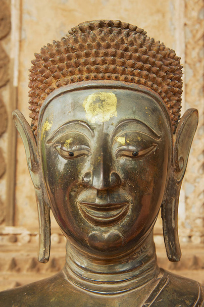 VIENTIANE, LAOS - 23 APRILE 2012: Testa della vecchia statua di Buddha situata sul muro esterno dell'edificio museale di Hor Phra Keo (ex tempio del Buddha di Smeraldo) a Vientiane, Laos
. - Foto, immagini