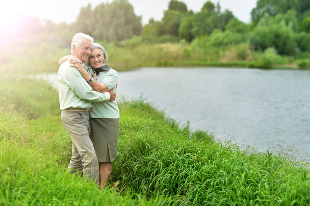 Loving mature couple near lake in summer - Fotografie, Obrázek