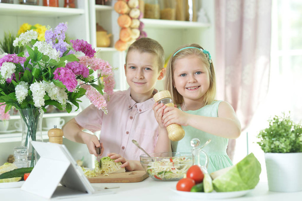 Cute little brother and sister cooking together at kitchen - 写真・画像