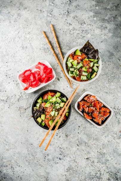 Азиатская модная еда, миска суши с огурцом, лосось, авокадо, семена черного и белого кунжута
 - Фото, изображение