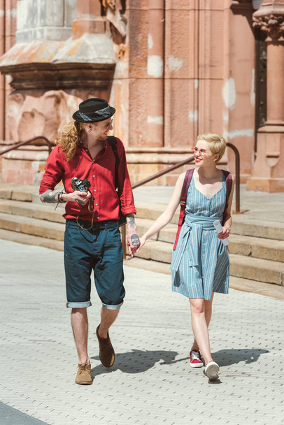 couple of tourists with camera holding hands and walking in city   - Fotó, kép