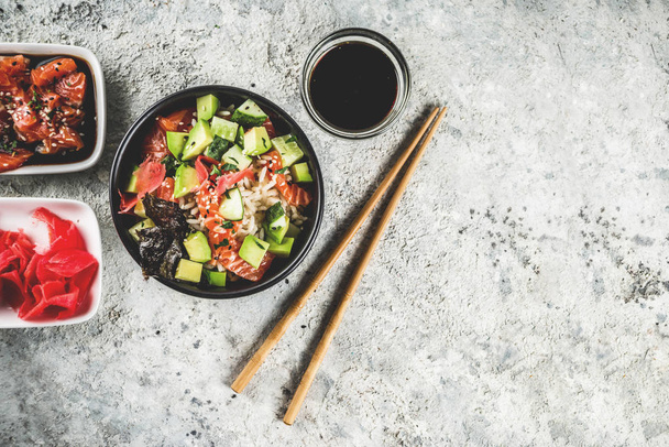 Comida de moda asiática, tazón de sushi poke con pepino, salmón, aguacate, semillas de sésamo blanco y negro
 - Foto, imagen