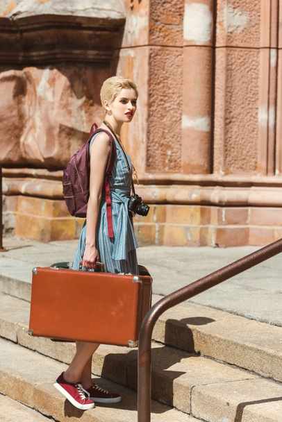 beautiful girl with backpack, camera and vintage suitcases - Valokuva, kuva