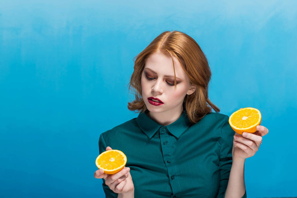 A beautiful woman with a bright make-up and well-groomed face skin holds an orange on her hand. Health, CARE, DIET CONCEPT - Photo, Image
