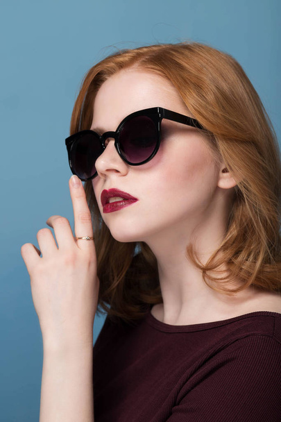 Sexy redhead woman in sunglasses. Studio shot - Foto, imagen