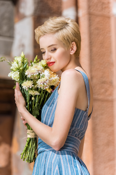 happy beautiful girl in trendy blue dress with bouquet of flowers - Fotó, kép