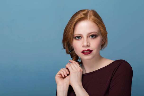Beautiful woman in portrait. Redhead girl with a serious face looking at the camera - Zdjęcie, obraz