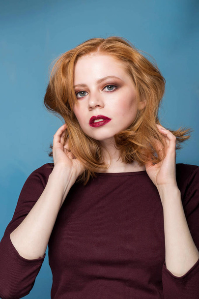 Close up portrait of a redhead girl on blue background. Beautiful woman with professional makeup, retouching. Fashion, fashion, cosmetics - Фото, зображення