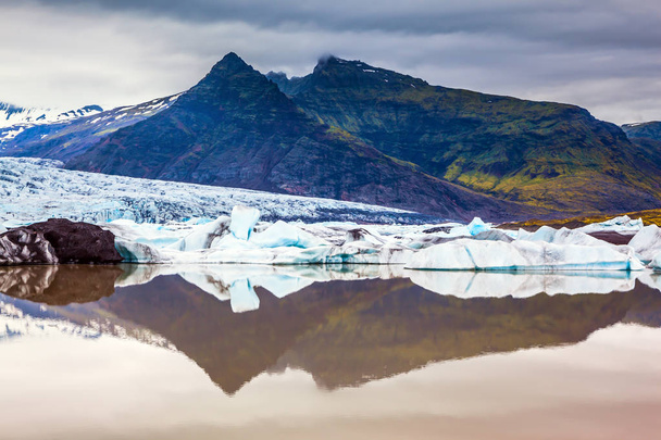 The concept of northern extreme tourism. The largest glacier in Iceland - Vatnajokull  in the summer sunset. Glacier provides water Jokulsarlon Ice Lagoon  - Photo, image