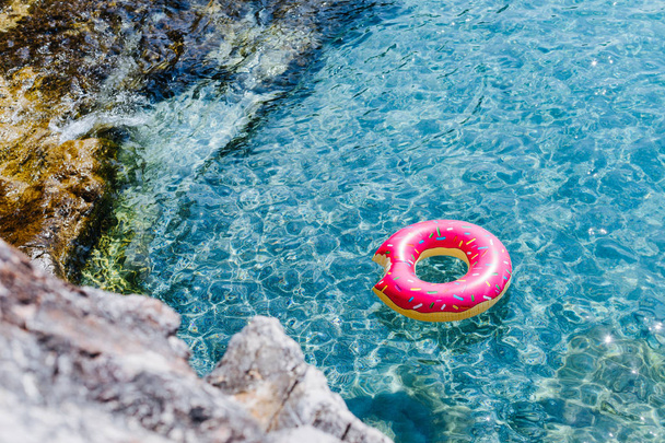 Pink doughnut ring floating on Mediterranean sea. - Foto, Bild