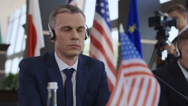Concentrated politician listening to translation on conference - Footage, Video