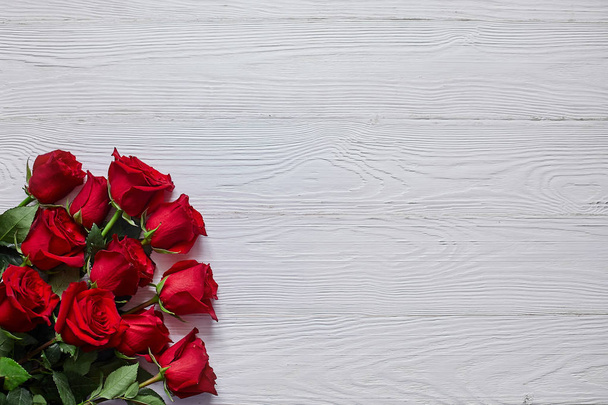 Bouquet of red roses on old white wooden background - Foto, afbeelding