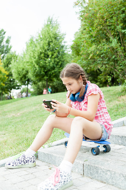 Girl having fun with her phone in the park  - Valokuva, kuva