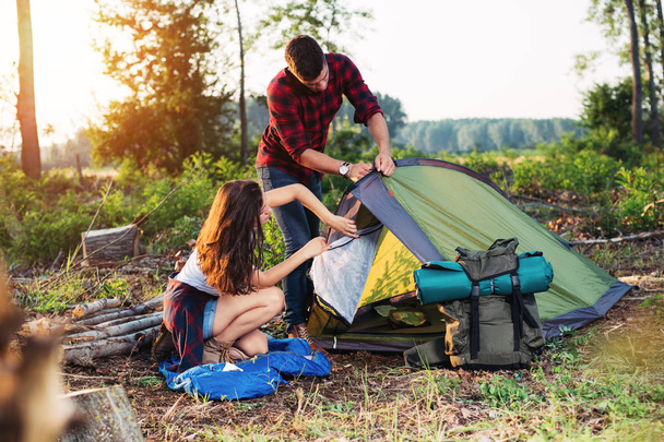 Young couple setting up tent outdoors,hiking and camping - Foto, afbeelding