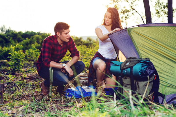 Young couple setting up tent outdoors,hiking and camping. - Photo, image