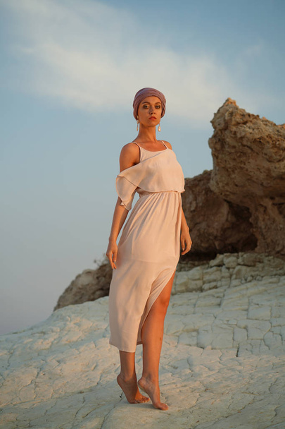 Γυναίκα στο φόρεμα του καλοκαιριού που θέτουν στους βράχους - σε εξωτερικούς χώρους - Φωτογραφία, εικόνα