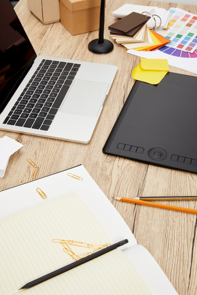 крупный план ноутбука, графического планшета, ноутбуков и поддонов на деревянной поверхности на графическом дизайнерском рабочем месте
 - Фото, изображение