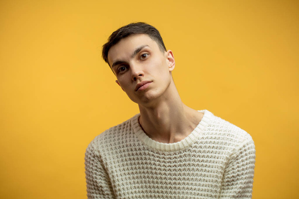 Portrait of a smart serious young man standing against yellow background - Fotoğraf, Görsel