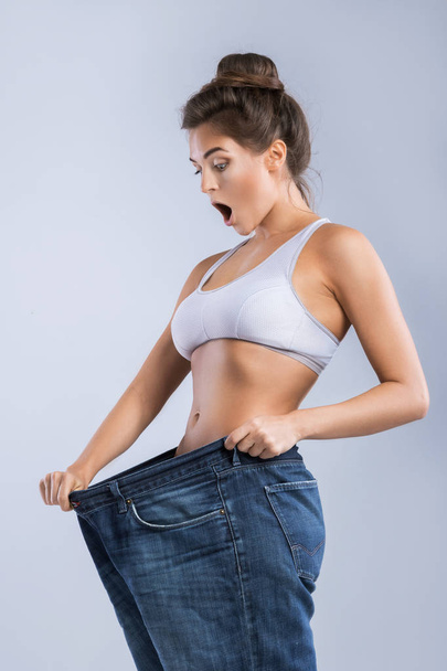 Happy woman after weight-loss is try her old jeans - 写真・画像