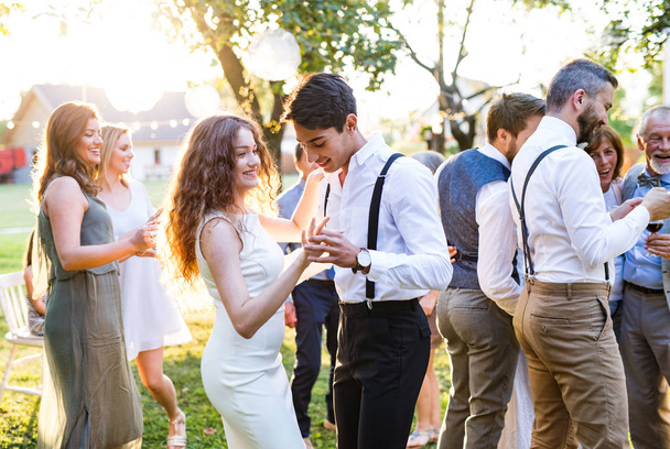 Guests dancing at wedding reception outside in the backyard. - Фото, зображення