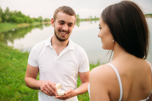 El hombre le hace una propuesta de matrimonio a una chica. Le da un anillo para el compromiso
 - Foto, Imagen