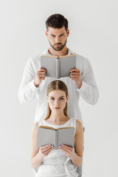 serious couple reading books isolated on grey background  - Photo, Image