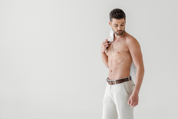 topless handsome man posing with shirt on shoulder isolated on grey background - Photo, Image