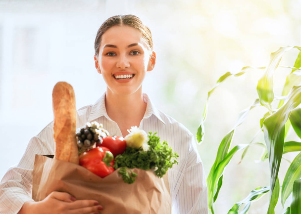 Young woman holding grocery shopping bag with vegetables. - Foto, Imagem