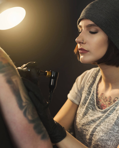 Mladá žena tattooist dělá tetování na rameno - Fotografie, Obrázek