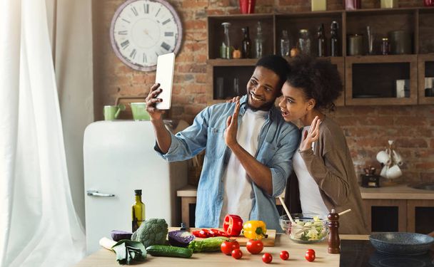 Schwarzes Paar mit digitalem Tablet und Gruß in Küche - Foto, Bild
