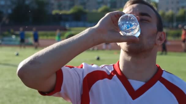 Weary footballer is drinking a water during the training - Felvétel, videó