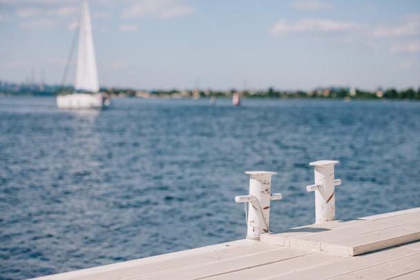 порожній дерев'яний пірс і яхта на фоні в літній день
 - Фото, зображення