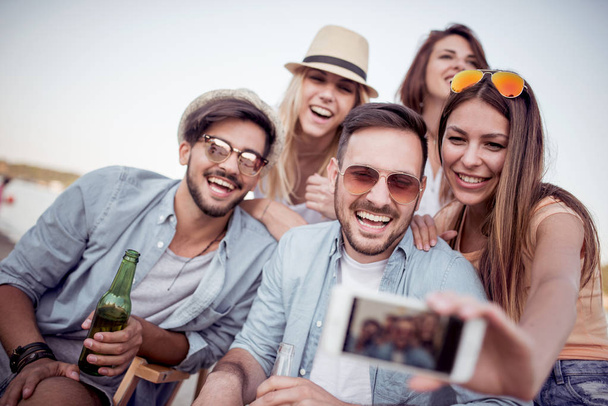 Літо, свята, відпустка та концепція щастя-група друзів, які приймають селфі зі смартфоном
. - Фото, зображення