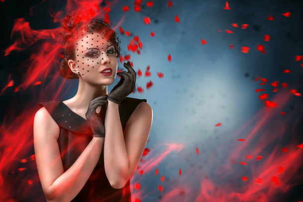 Abstract fashion portrait of young woman with flame and smoke over dark background - Fotografie, Obrázek