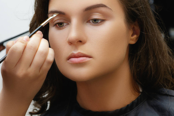 Καλλιτέχνης μακιγιάζ εφαρμογή καλλυντικών στο πρόσωπό του μοντέλου - Φωτογραφία, εικόνα