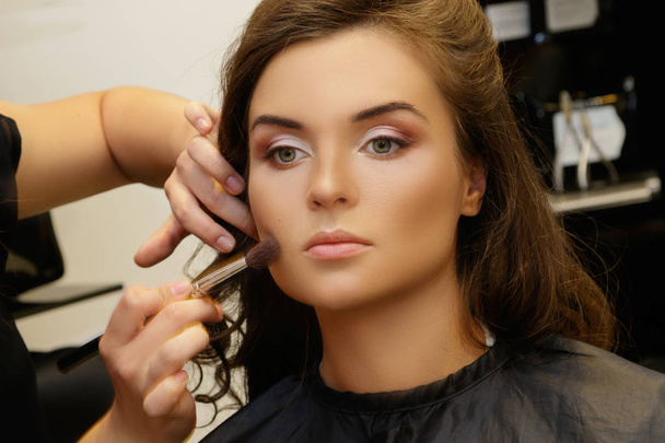 Makeup artist applying cosmetics on model face - Φωτογραφία, εικόνα