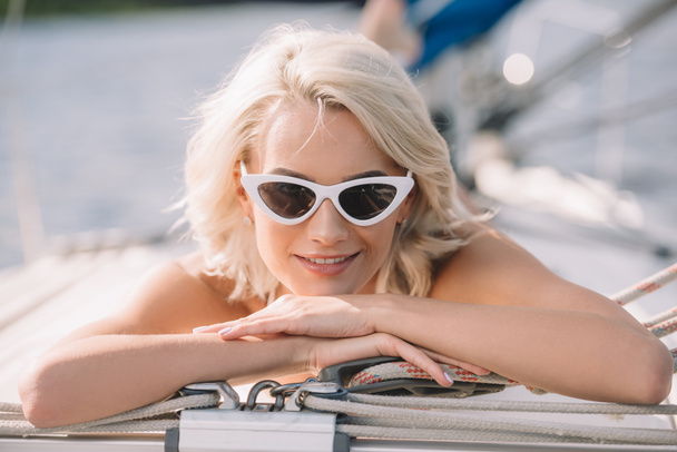 foyer sélectif de la jeune femme attrayante dans les lunettes de soleil posées sur le yacht
  - Photo, image