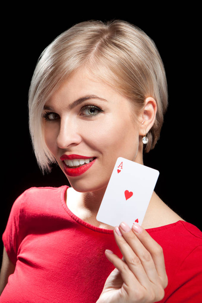 Beautiful blond girl showing a poker card - Foto, afbeelding