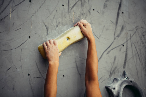 Climber hands holding artificial boulder in climbing gym, closeup shot - Fotografie, Obrázek