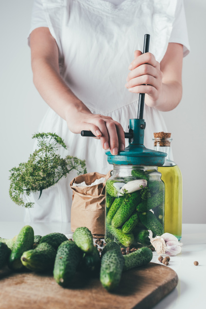 cropped image of woman preparing preserved cucumbers at kitchen - Foto, afbeelding